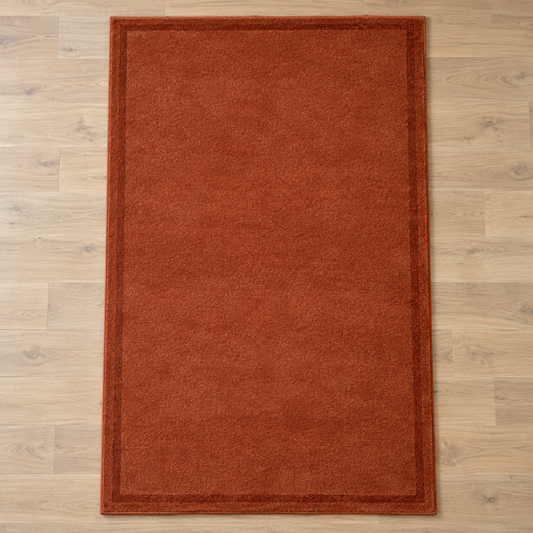 Rust plain hand tufted single border rug