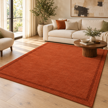 Terracotta Plain Hand Tufted Rug – Subtle Single Border styled in a decorated living room with sofa